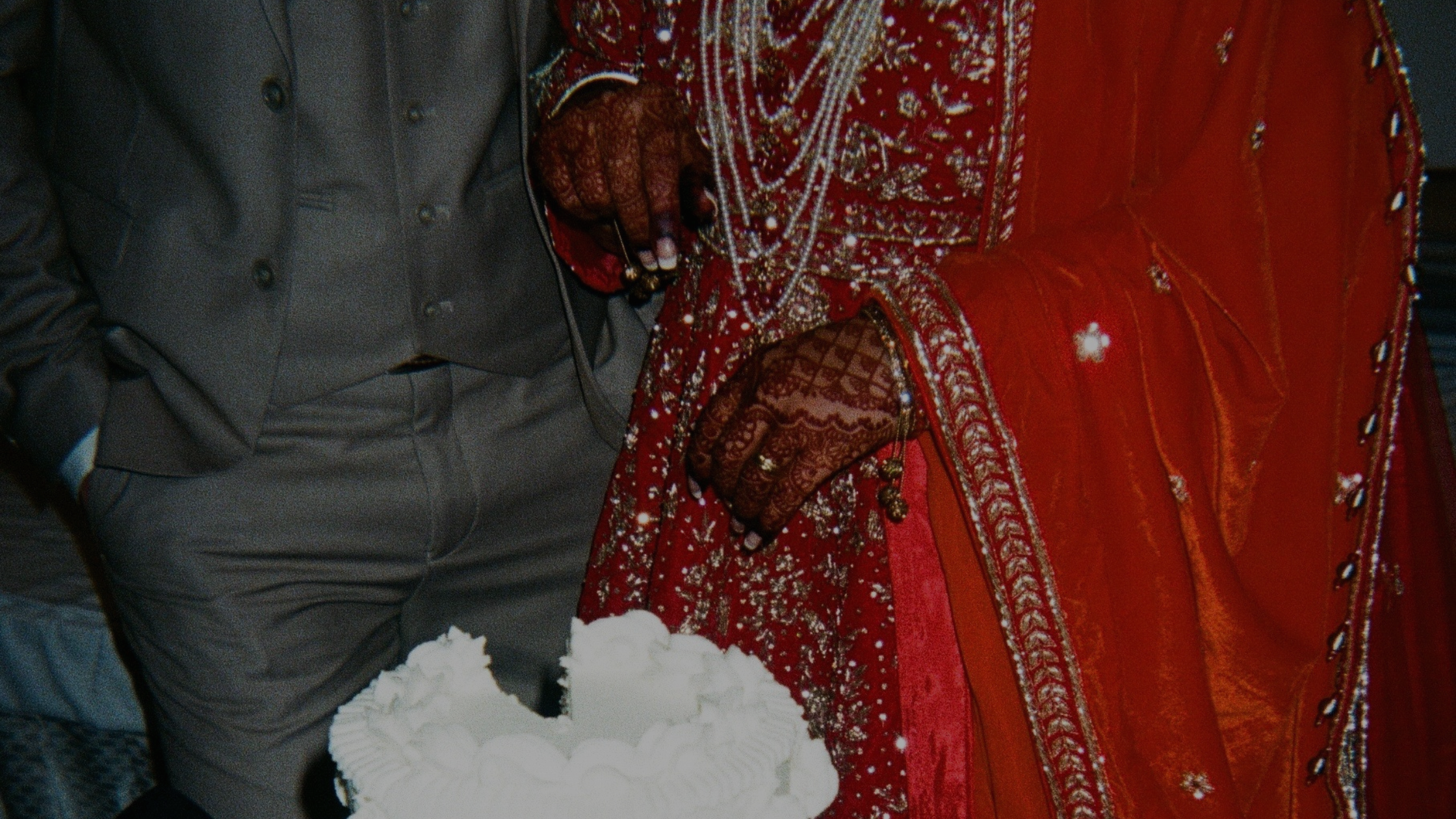 Zoomed in image of a couple cutting a cake at their wedding.