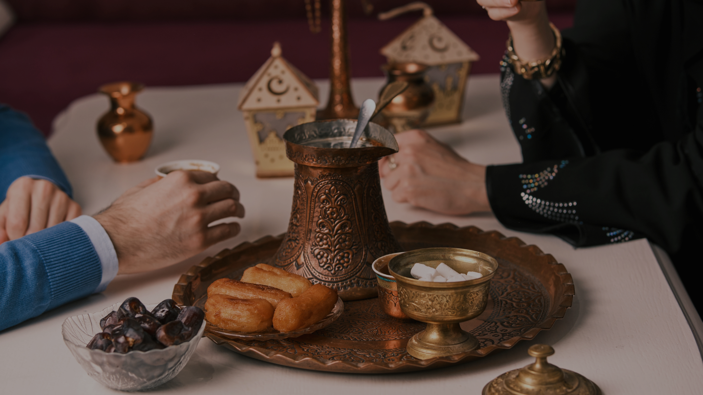 A dinner table with people drinking chai.