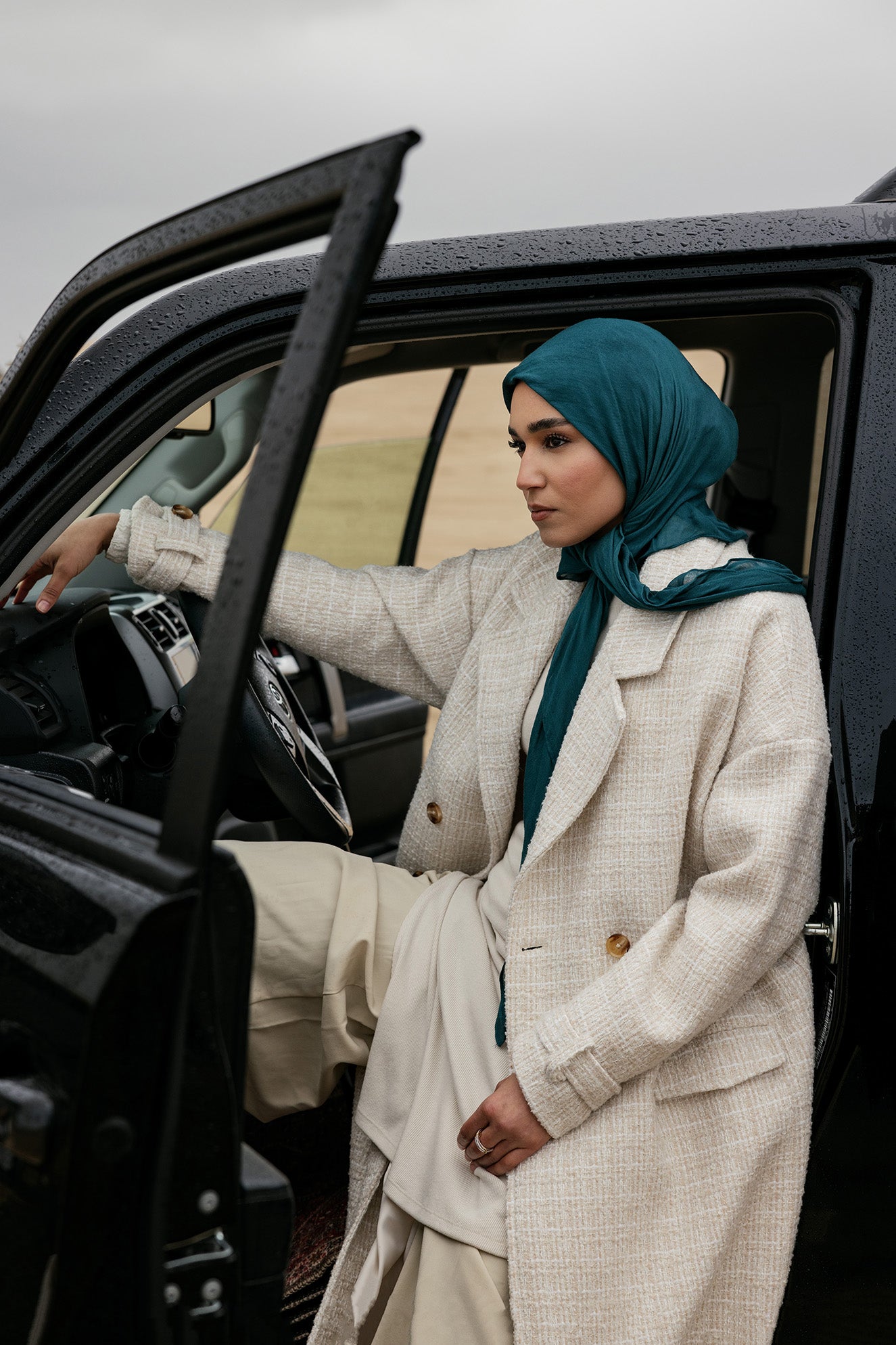 Structured outerwear piece designed for full coverage with classic trench coat appeal