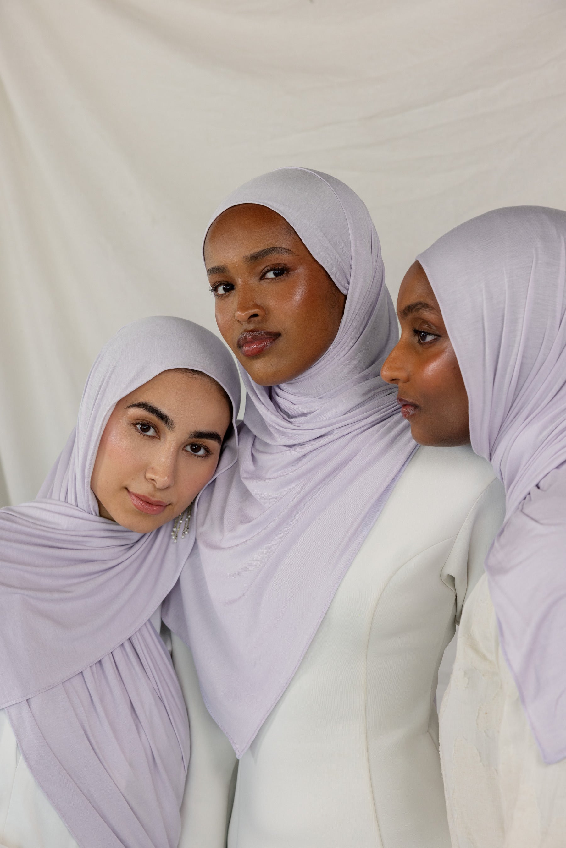 Three models wearing Soft Amethyst Jersey Lite, capturing its soft purple tone from different angles.