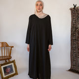 Black full-length underdress with a smooth finish, perfect for layering or wearing solo