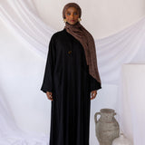 Structured linen abaya offering both comfort and convenience with integrated pockets.