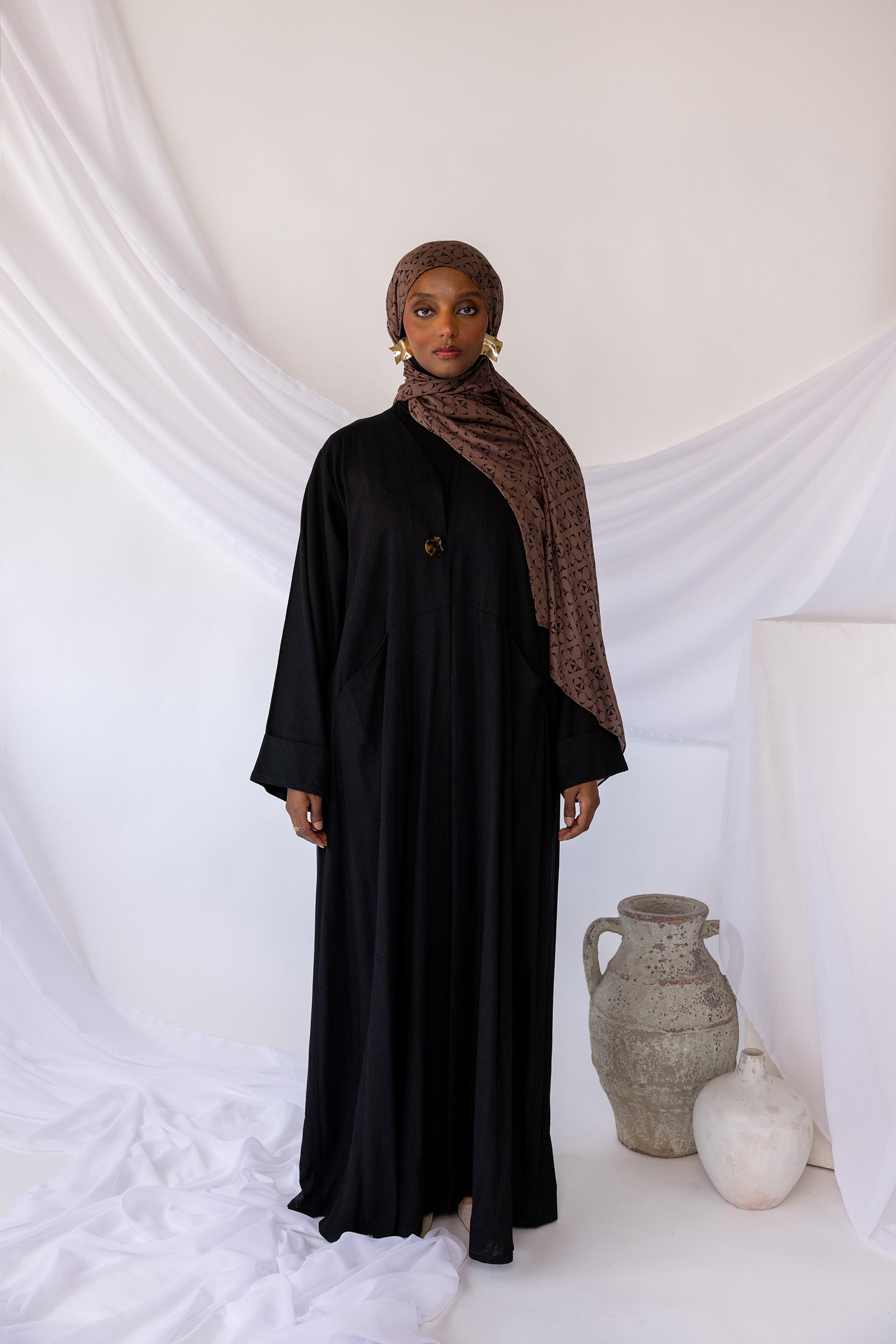 Structured linen abaya offering both comfort and convenience with integrated pockets.