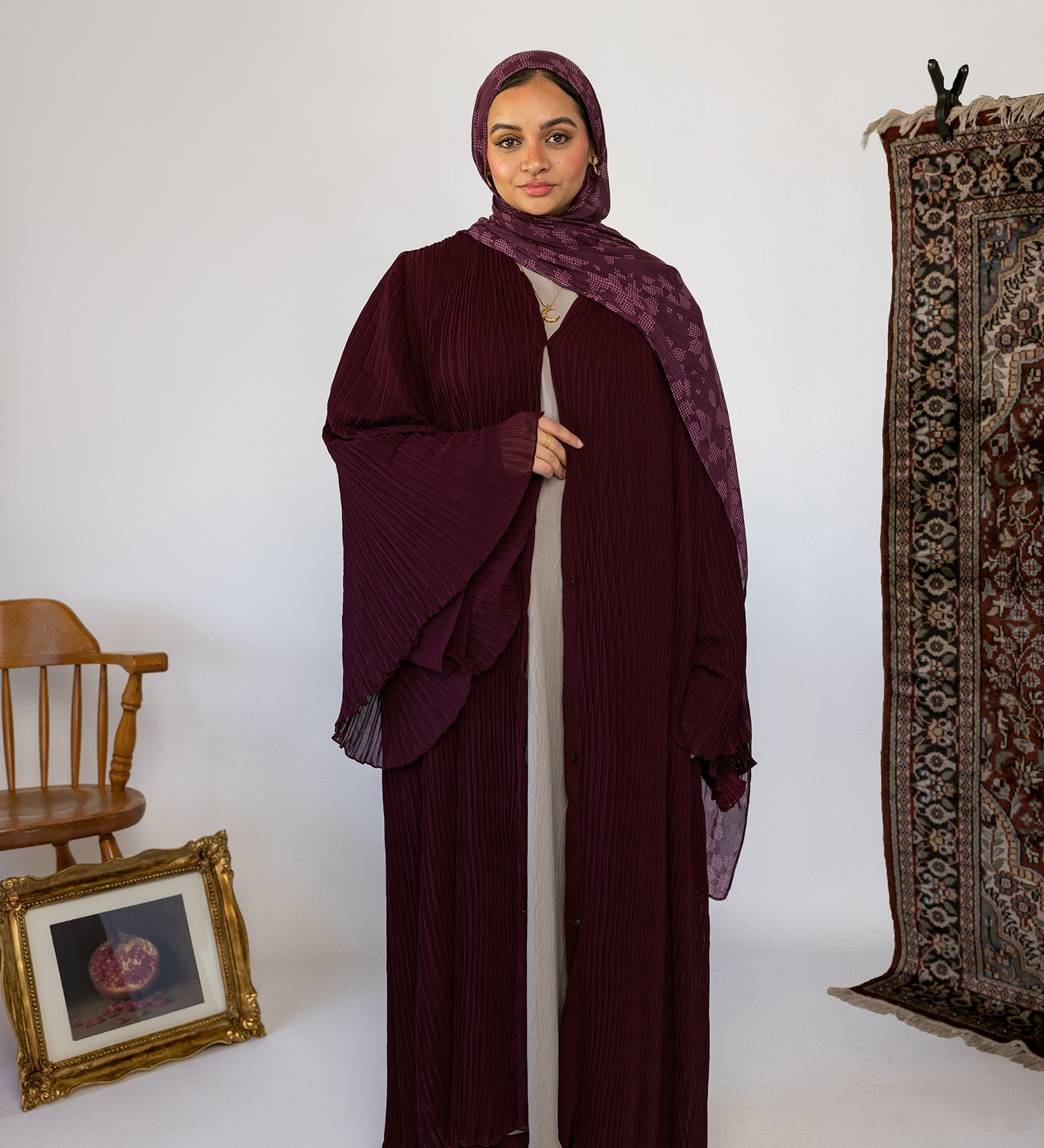 Flowy pleated abaya designed with soft fabric and full-length movement.