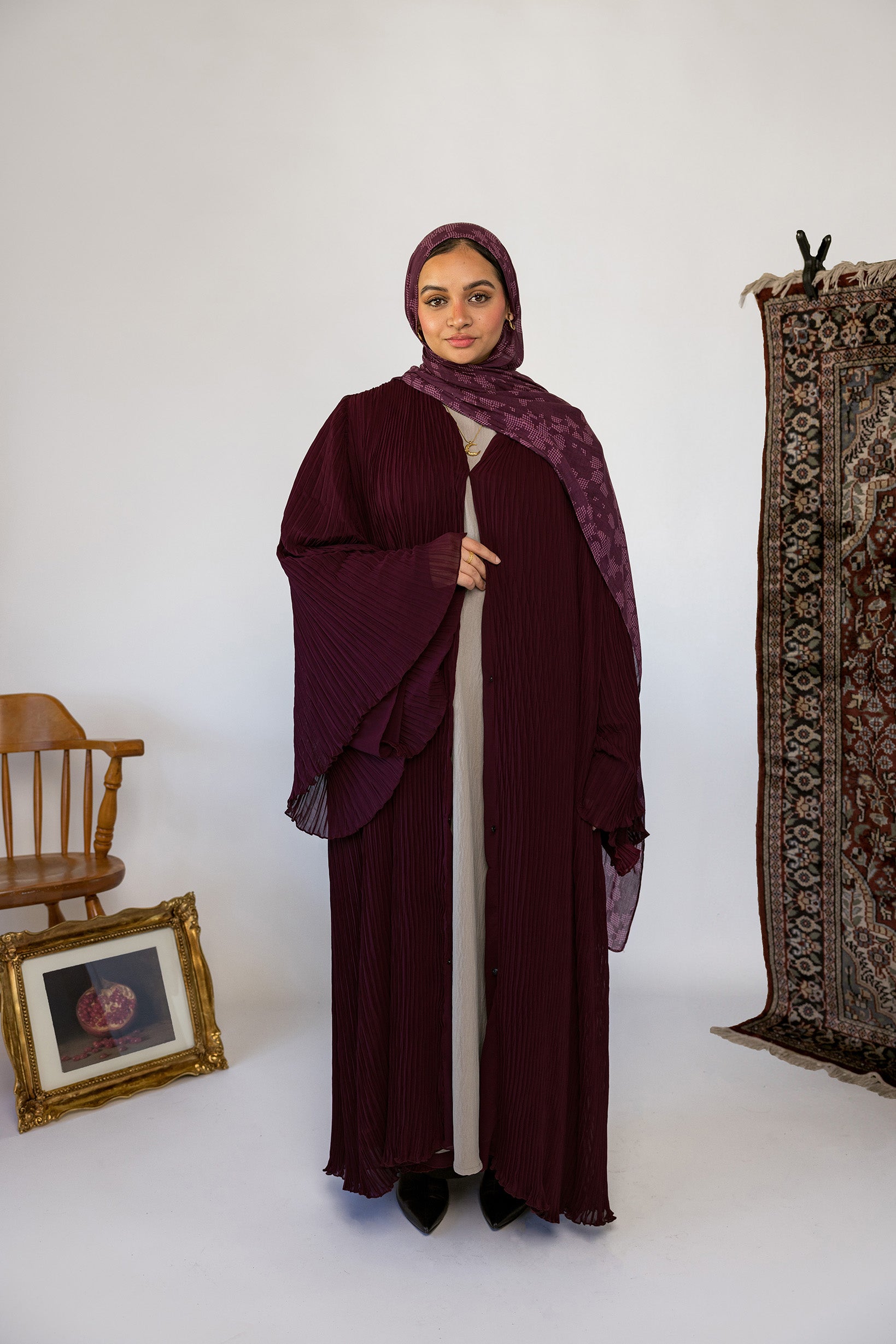 Flowy pleated abaya designed with soft fabric and full-length movement.