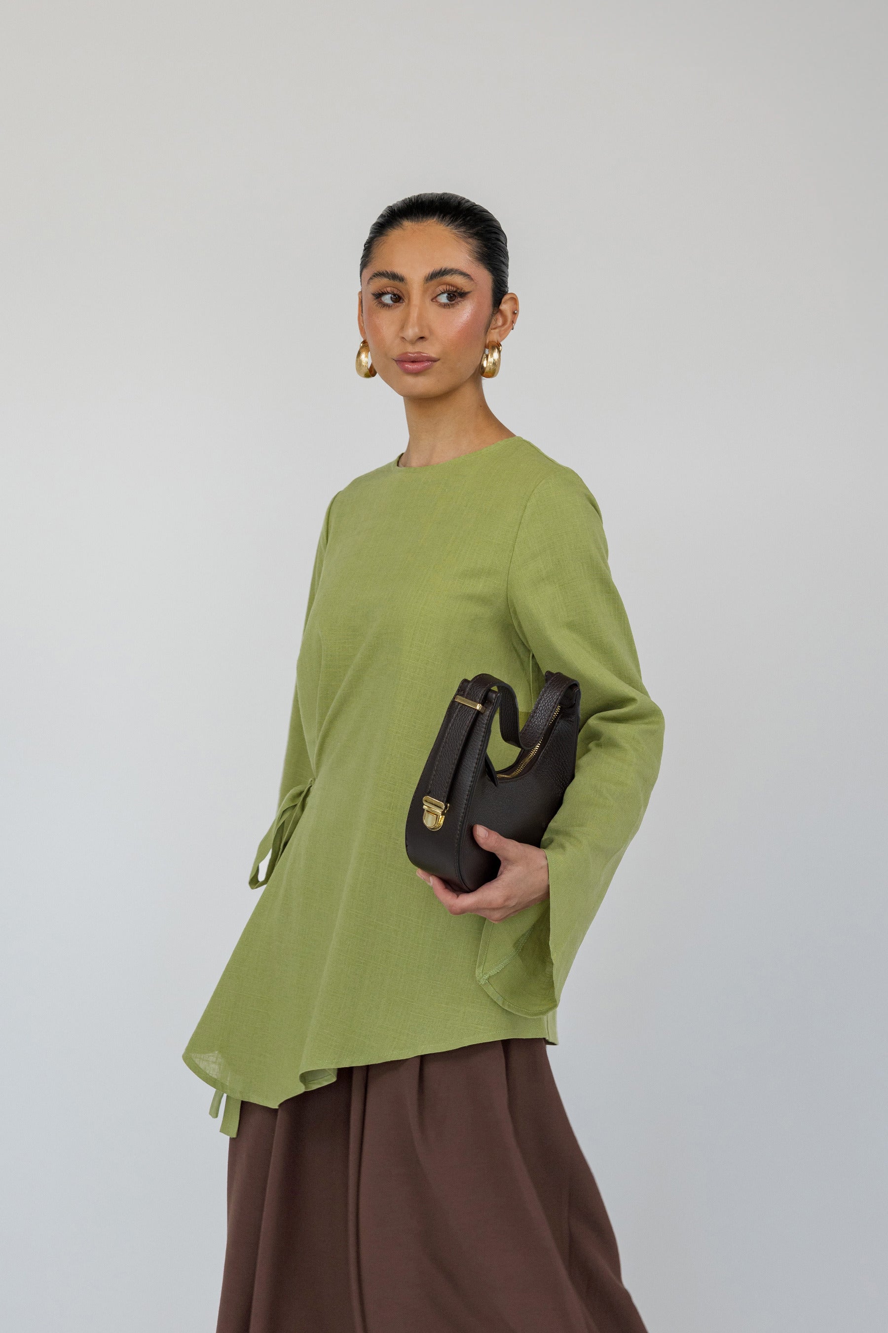 Airy top with a loose shape and simple front tie, designed for comfort and movement.
