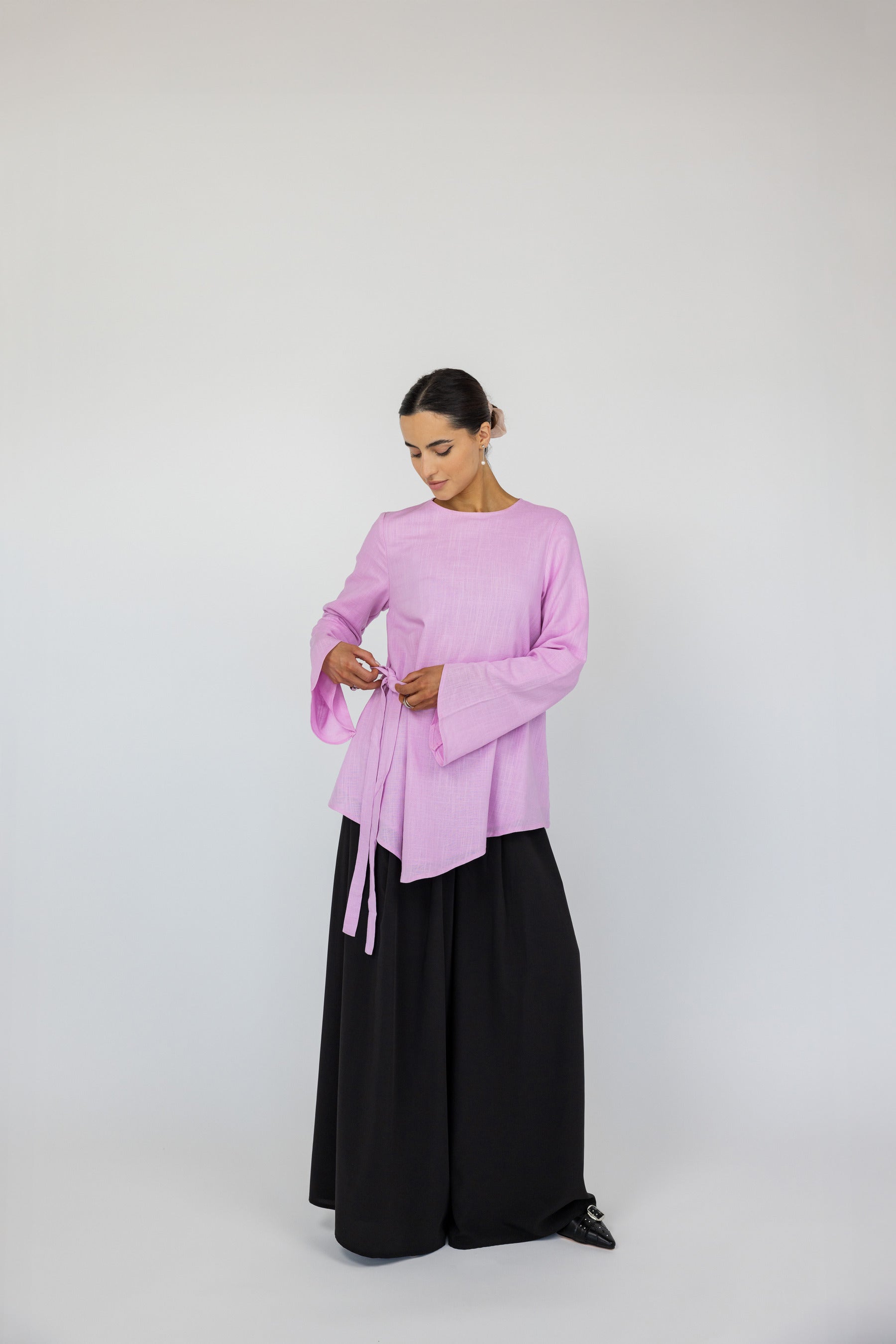Loose-fit top with a front tie and lightweight fabric, designed for all-day comfort.