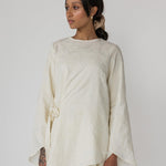 Cream-colored textured top with a gentle drape and feminine front tie