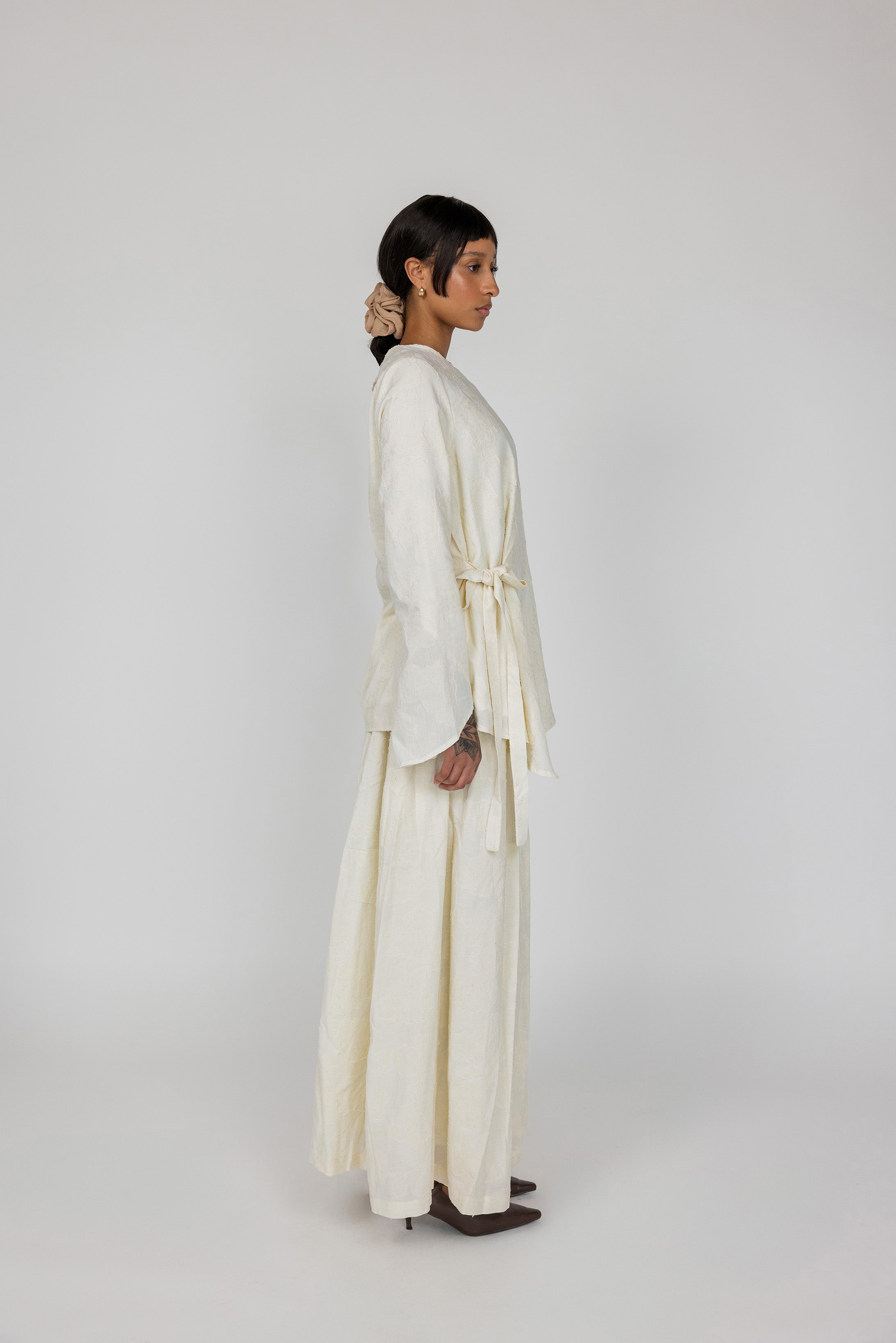 Modest cream top with full coverage and a soft tie-front design, made from textured rayon-linen fabric.