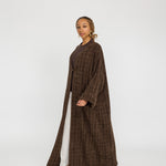 Modest tweed abaya designed with a relaxed fit and rich, woven texture