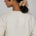 Modest cream blouse with natural texture and adjustable tie for flexible, covered looks