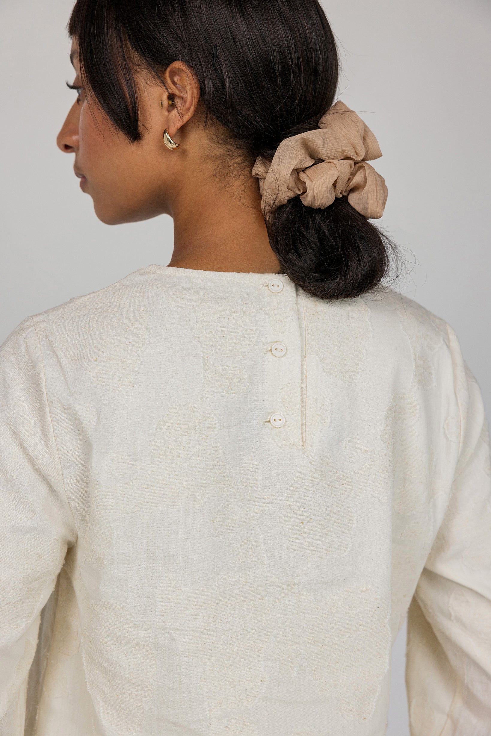 Modest cream blouse with natural texture and adjustable tie for flexible, covered looks