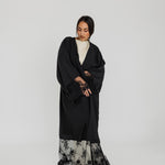 Lace-trimmed abaya with flowing fabric and delicate detailing for a refined finish.