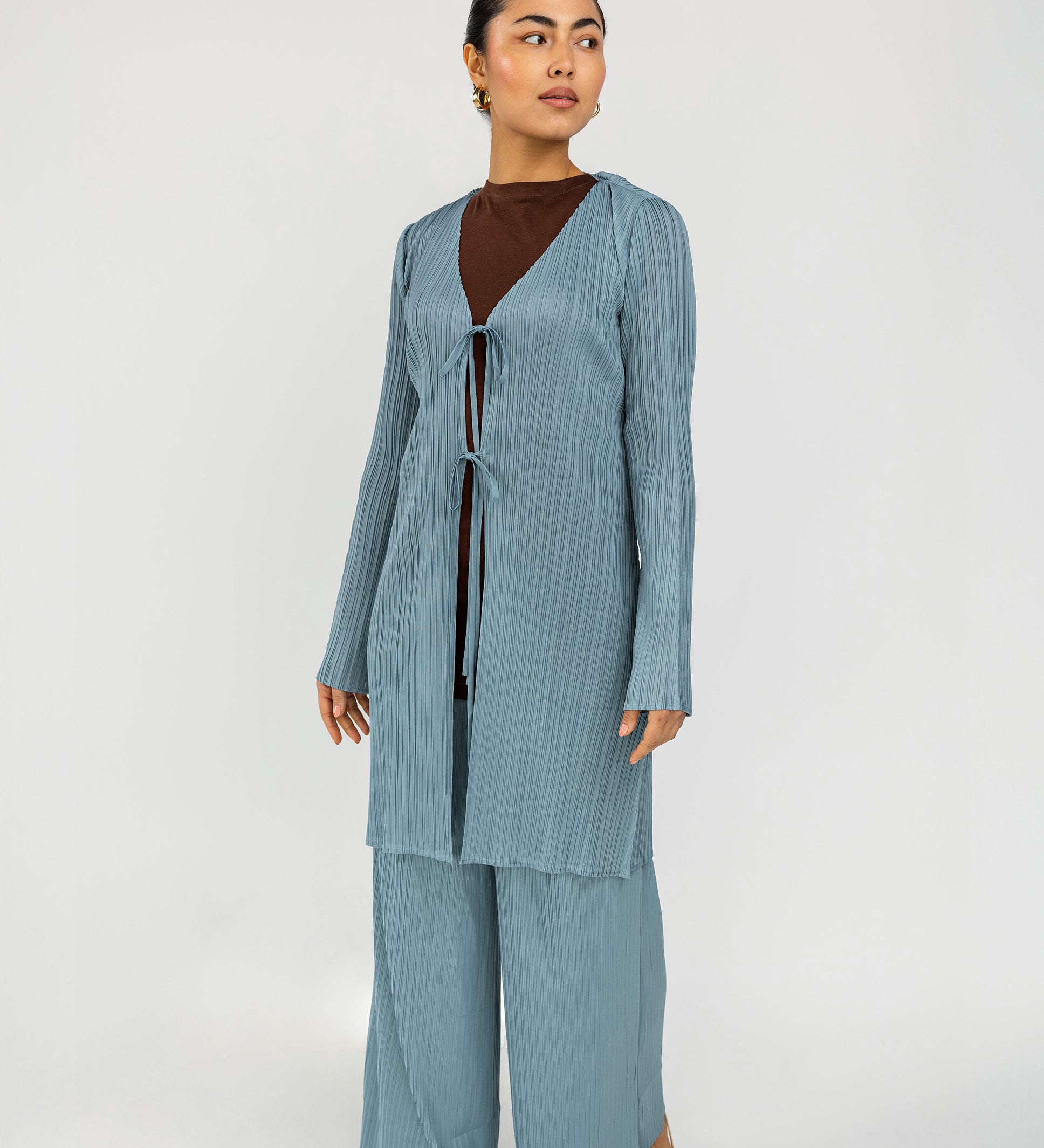 Relaxed pleated pants featuring a smooth waistband and elegant movement