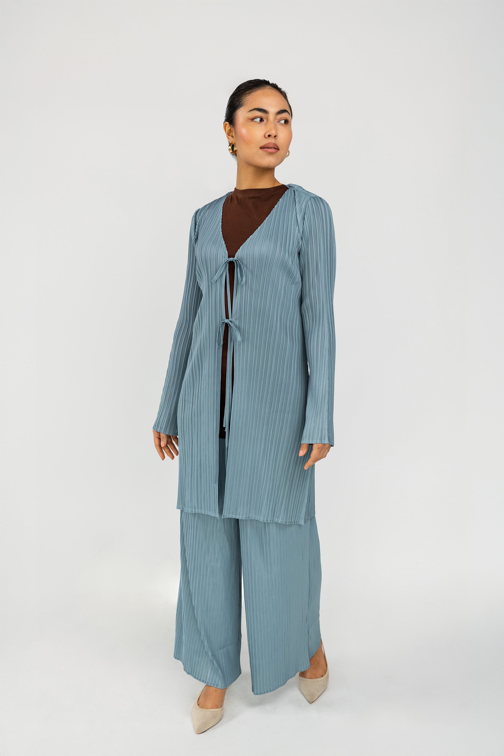 Relaxed pleated pants featuring a smooth waistband and elegant movement