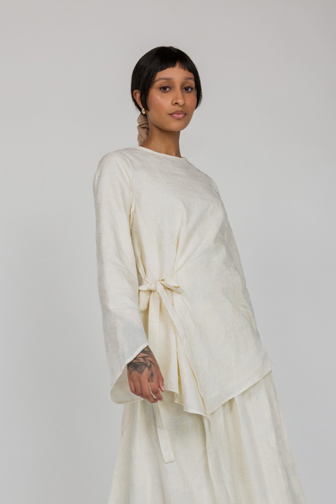 VELA textured cream top featuring a front tie and light, flowy fabric