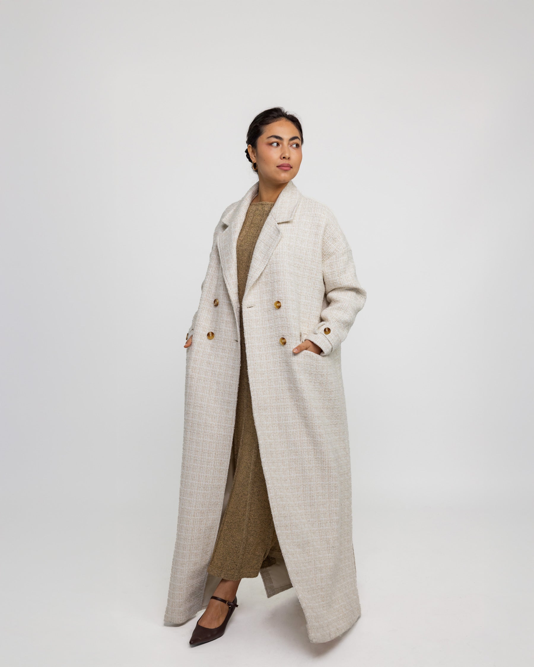 Outerwear abaya designed with trench coat elements and a soft, draped fit