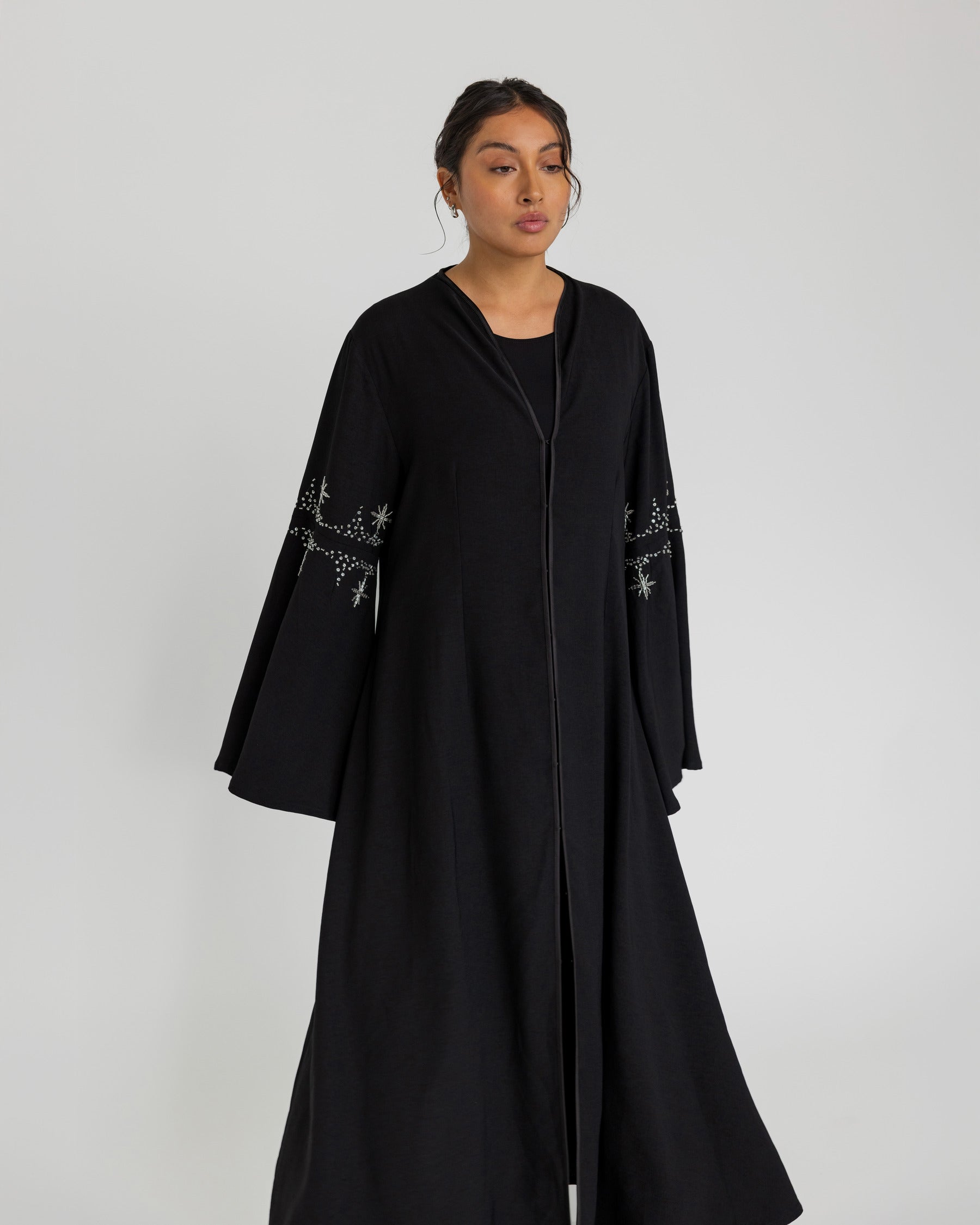 Jeweled abaya with a modest, fluid shape and elegant sleeve flare