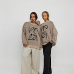 Oversized sweater with arabesque-inspired knit design and subtle stitched logo detail.