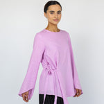 Flowy everyday top with a clean neckline, long sleeves, and subtle tie at the waist.