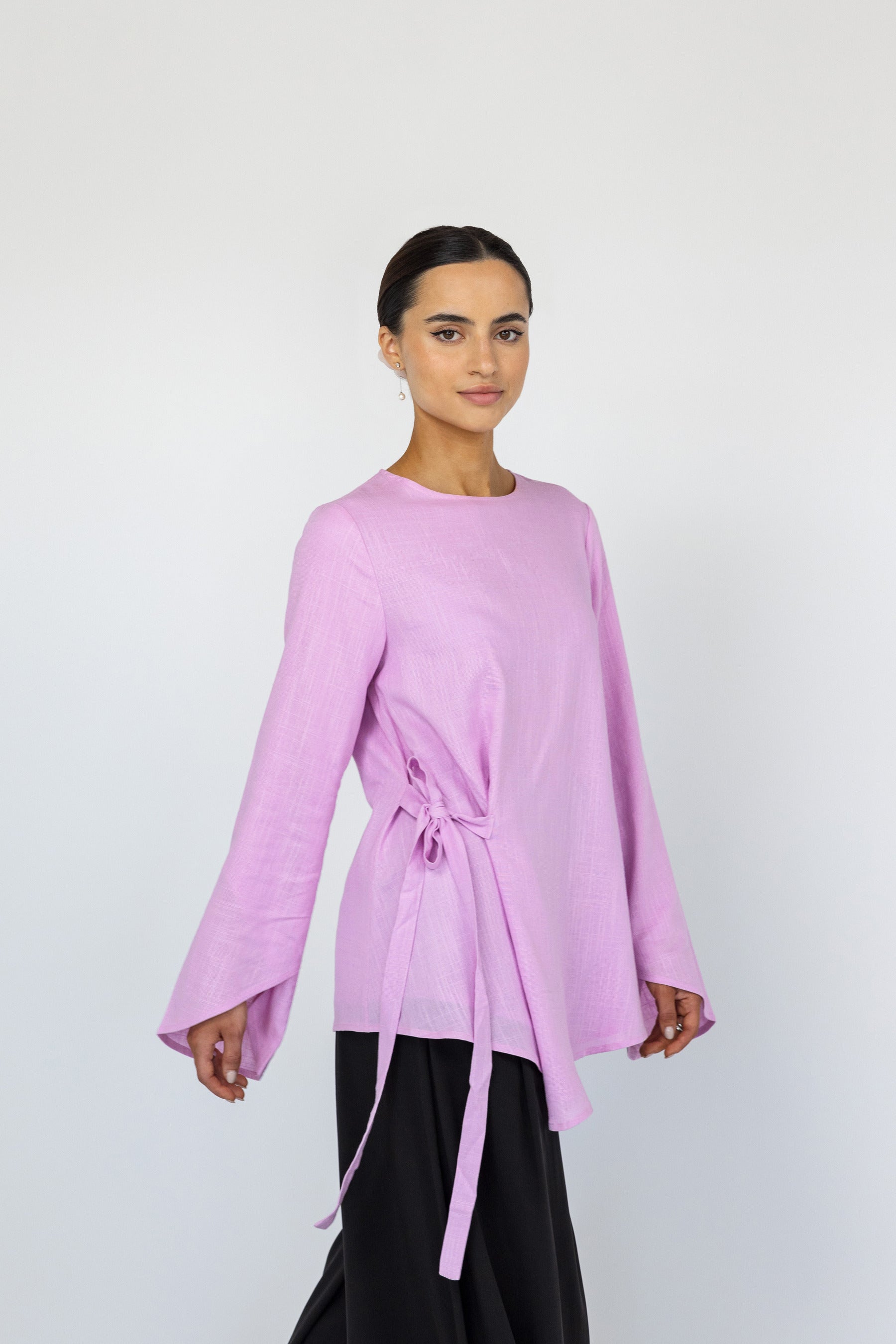 Flowy everyday top with a clean neckline, long sleeves, and subtle tie at the waist.