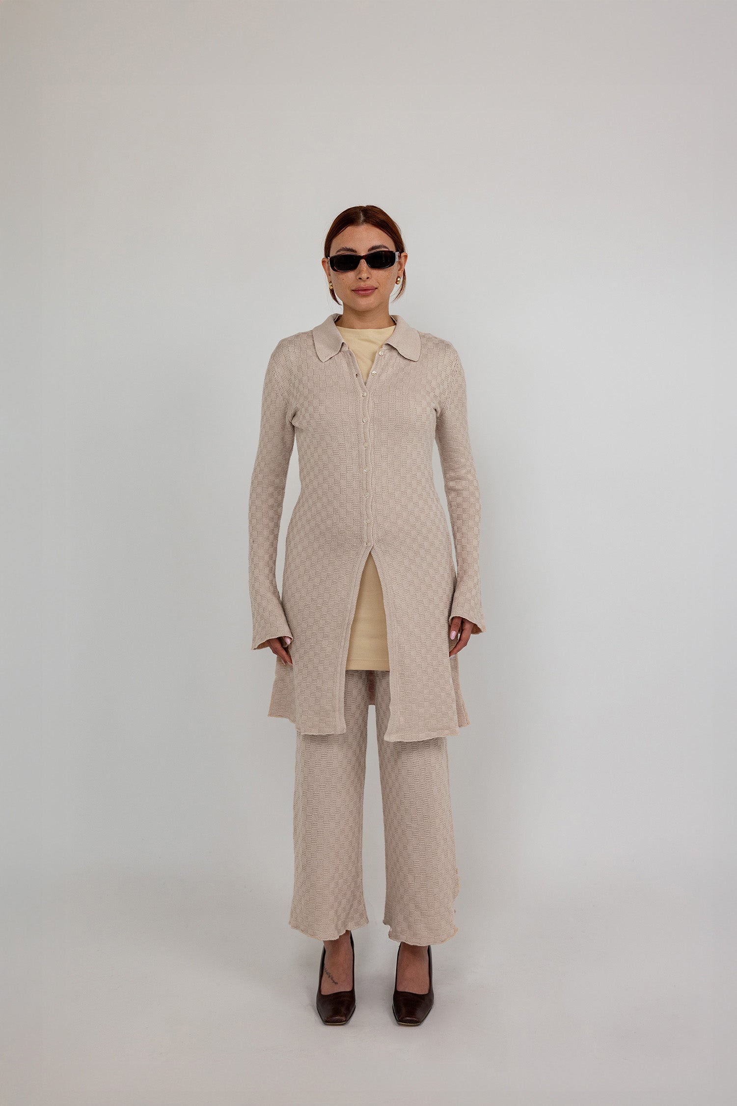 Fitted knit cardigan with a check pattern and modest full-length coverage.