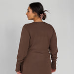 Woman wearing a brown outfit against a plain background
