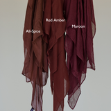 Maroon hijab hanging next to other shades for a side-by-side comparison of color depth and tone.