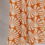 Fabric with orange shell pattern against a plain background