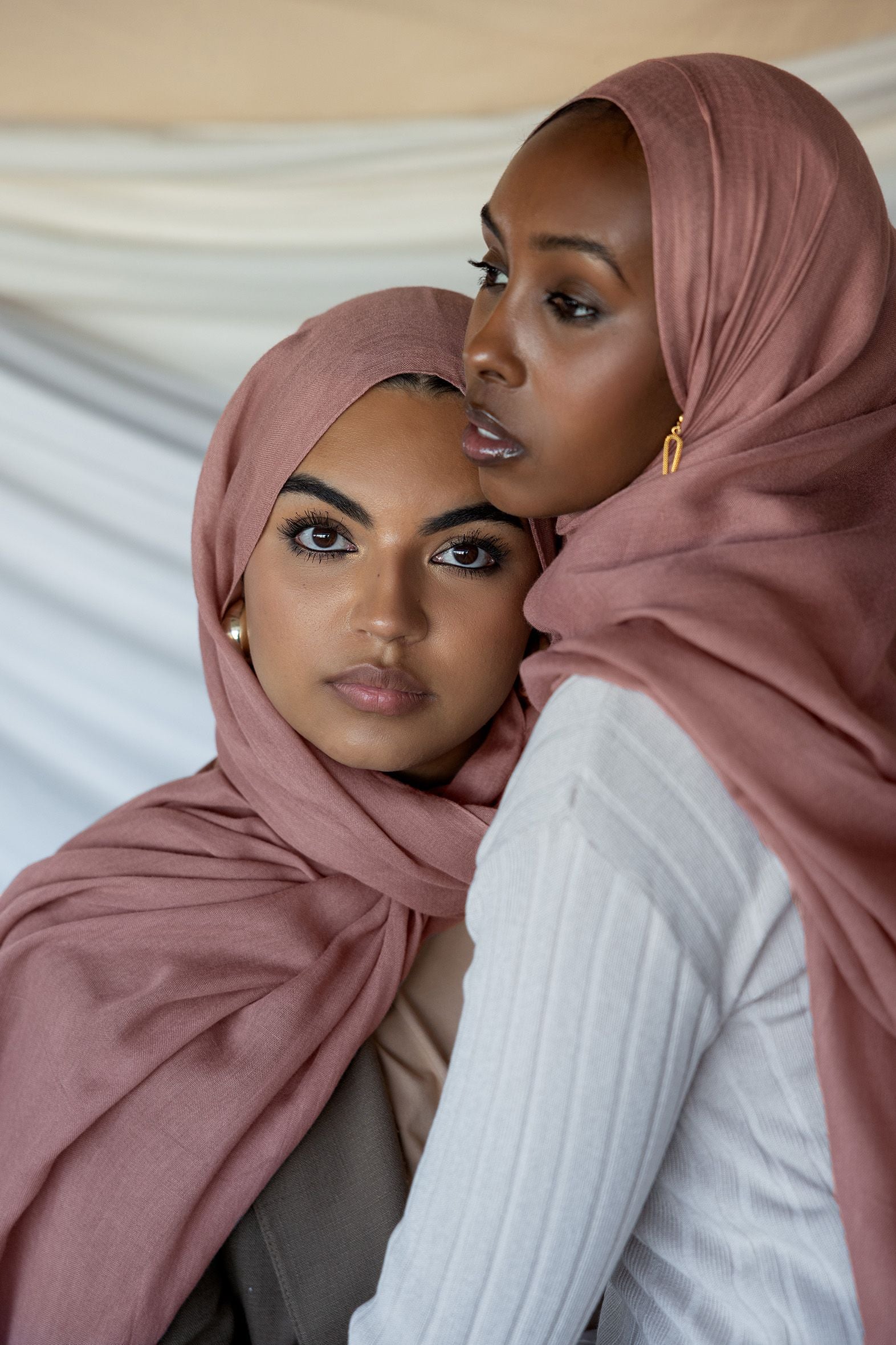 Two models wearing Blush hijab in front of backdrop.