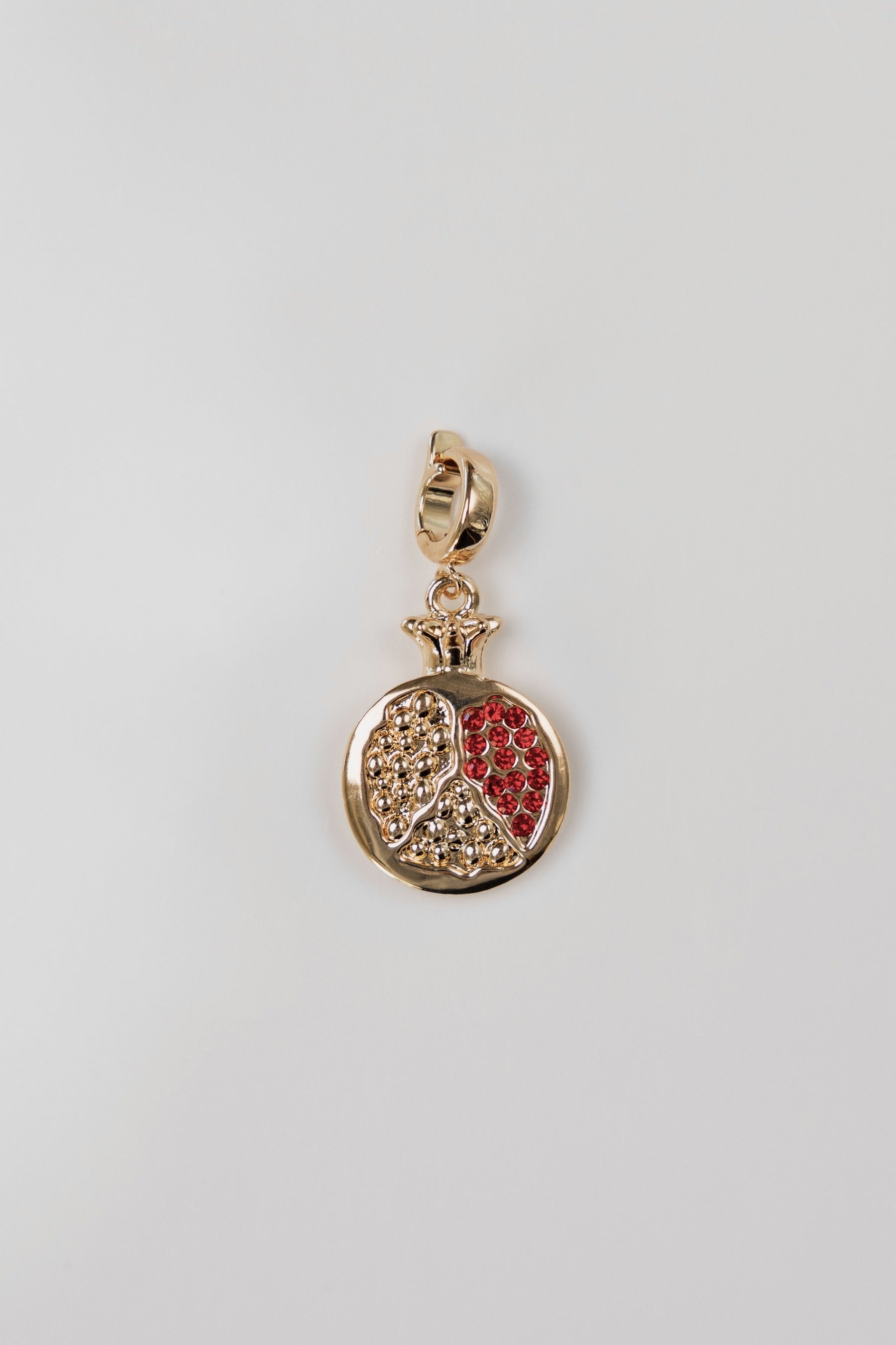 Gold pomegranate charm with red detailing.