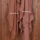 Color comparison of two brown hijabs draped over a wooden surface with color swatches labeled 'Toasted Pecan' and 'Fawn Brown'.