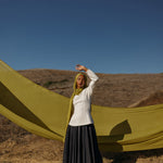 Model wearing Guava Green hijab standing in field.