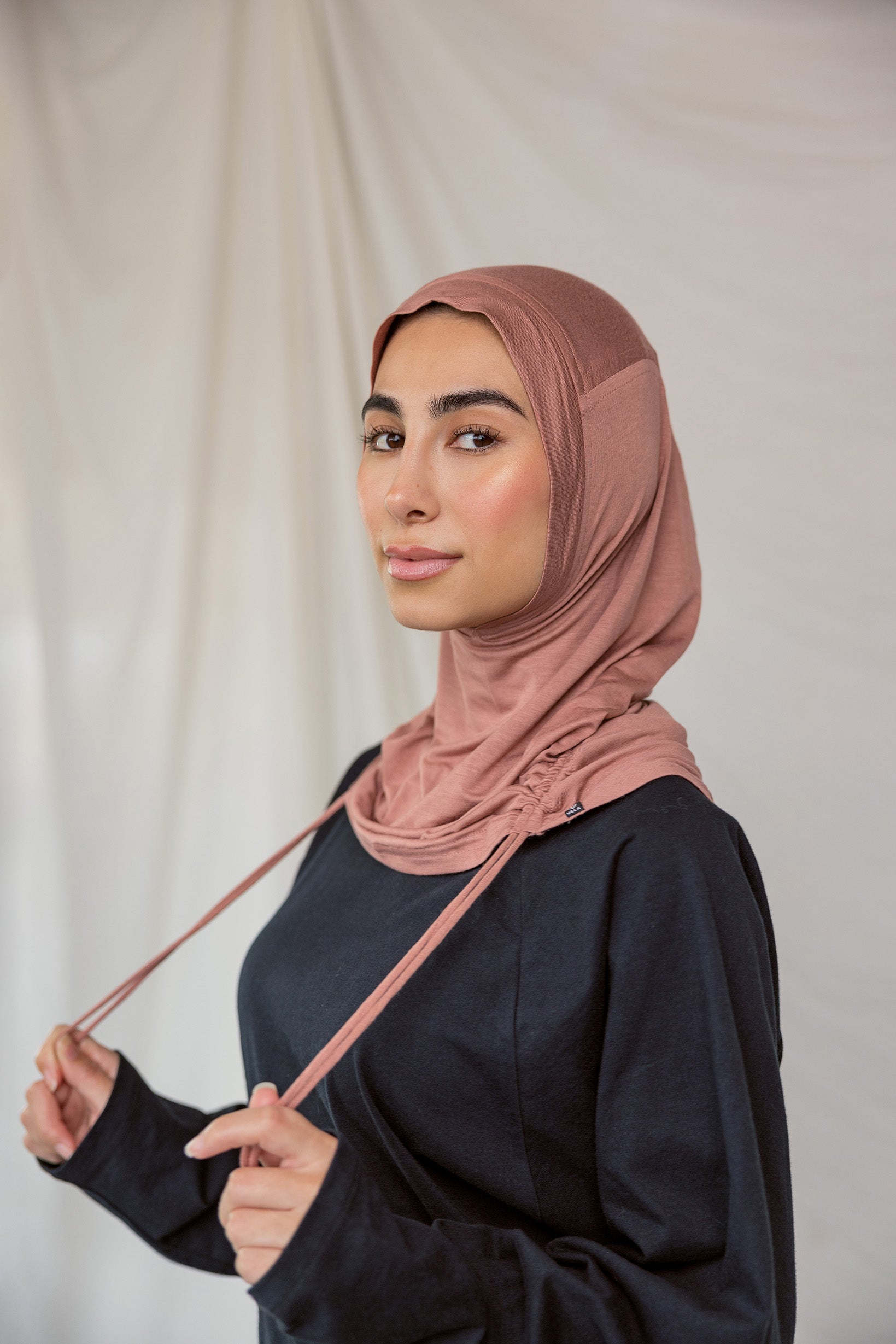 Model wearing Terra Blush Ruching Lite, showing warm pink hue styled in the unruched way.