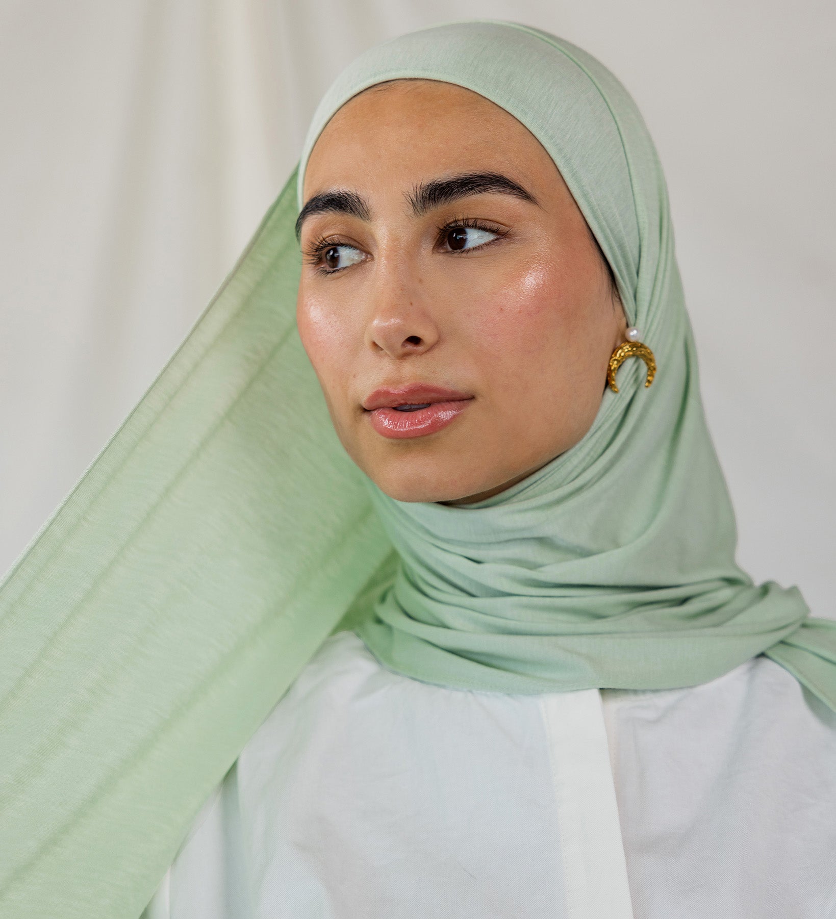 Model wearing Sage Mist Jersey Lite with a soft drape around the shoulders, highlighting its lightweight, wrinkle-resistant finish.
