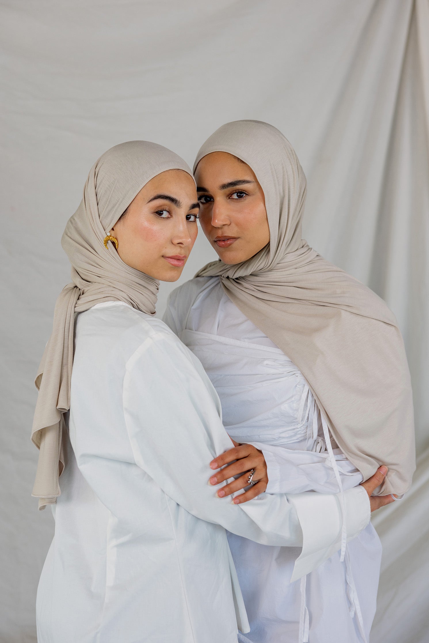 Two models wearing Ashwood Jersey Lite, highlighting its warm beige tone in different wrap styles.