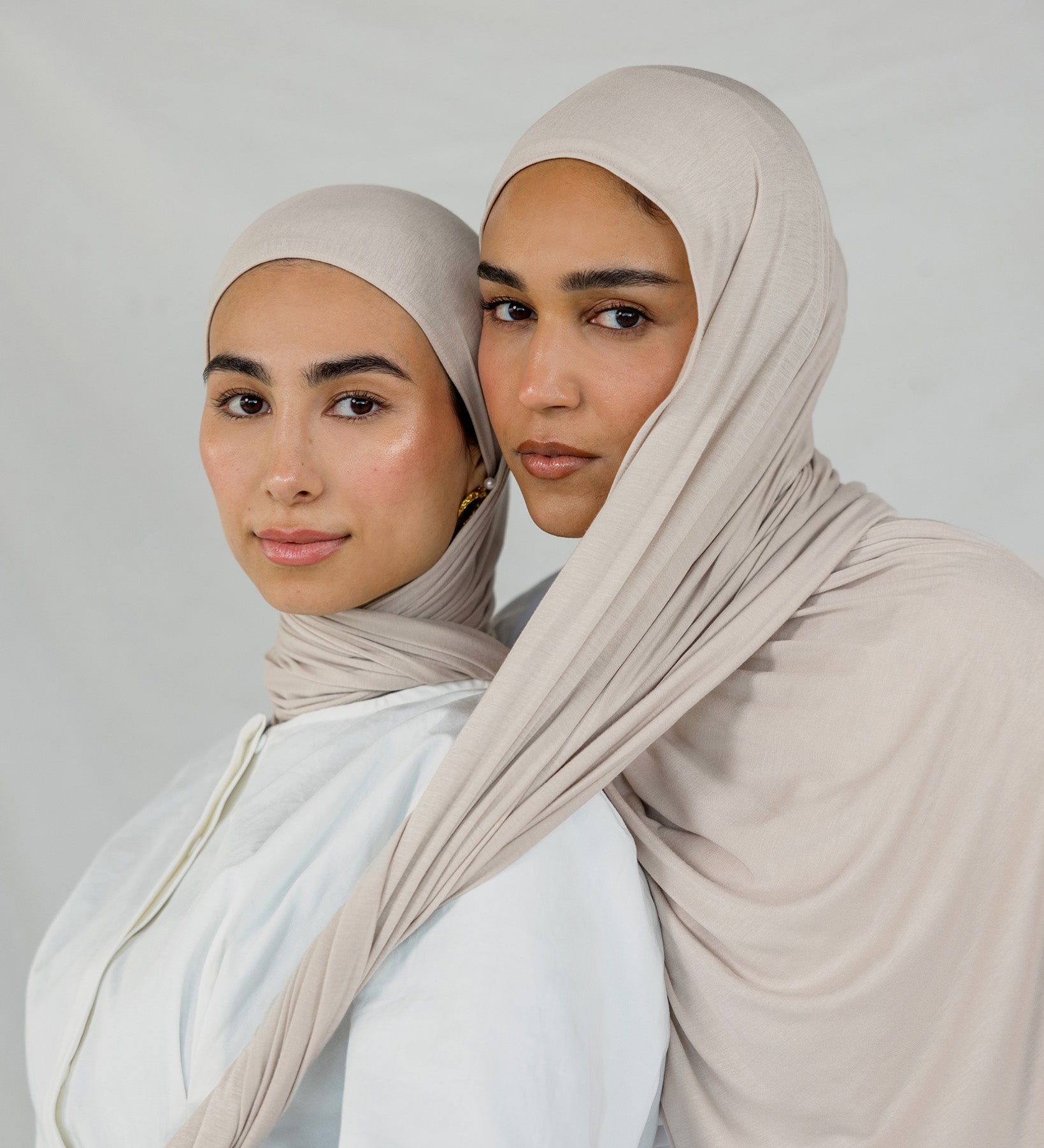 Two models wearing Ashwood Jersey Lite, highlighting its warm beige tone and flex fabric.