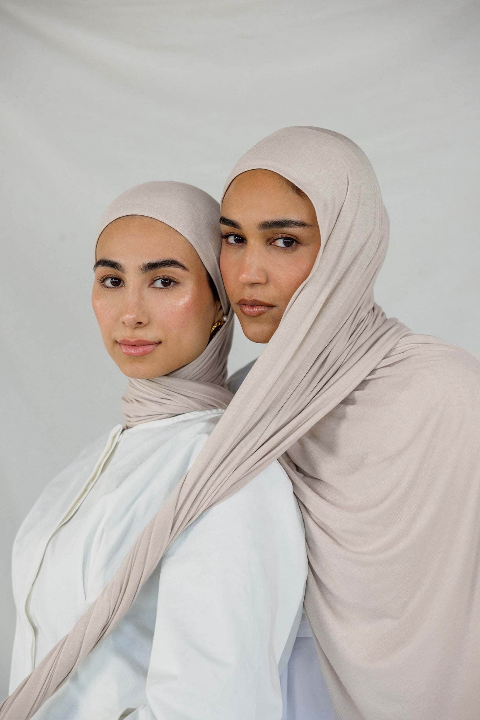 Two models wearing Ashwood Jersey Lite, highlighting its warm beige tone and flex fabric.