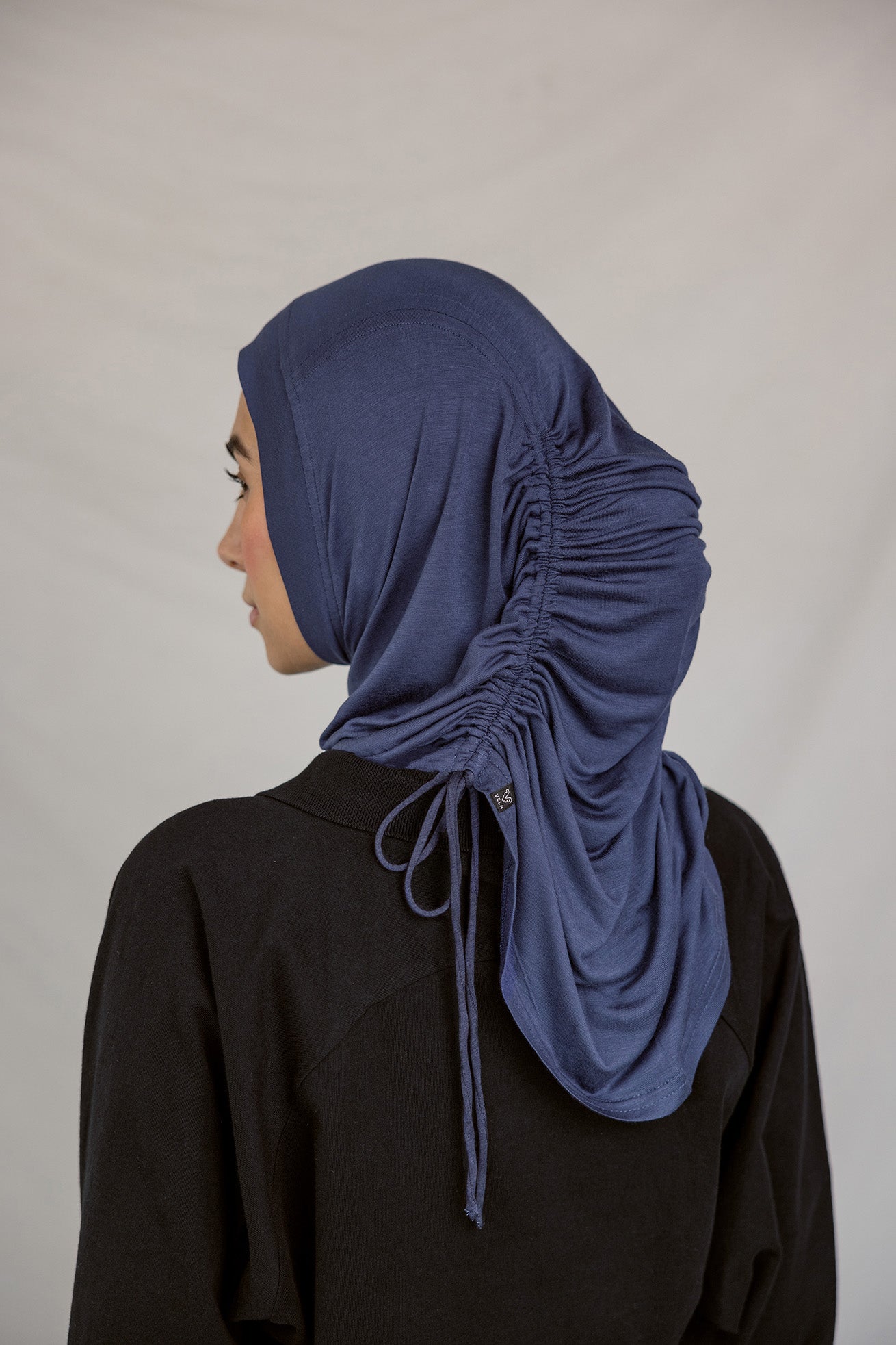 Back view of model wearing the Twilight Blue Ruching Lite hijab, fully-styled.