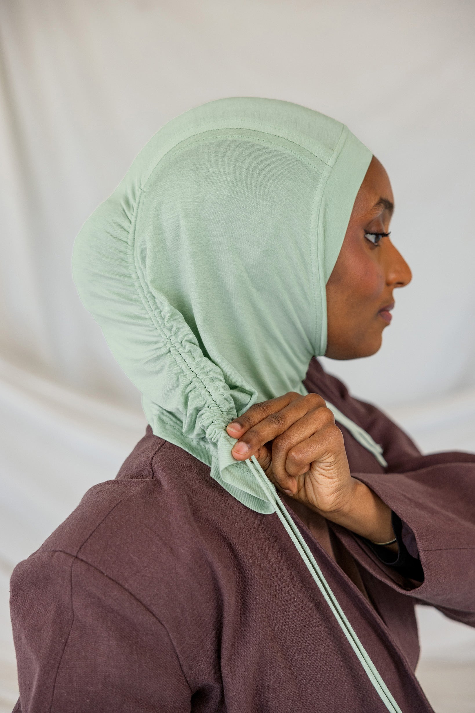 Model wearing Sage Mist Ruching Lite, highlighting minty sage tone and texture.