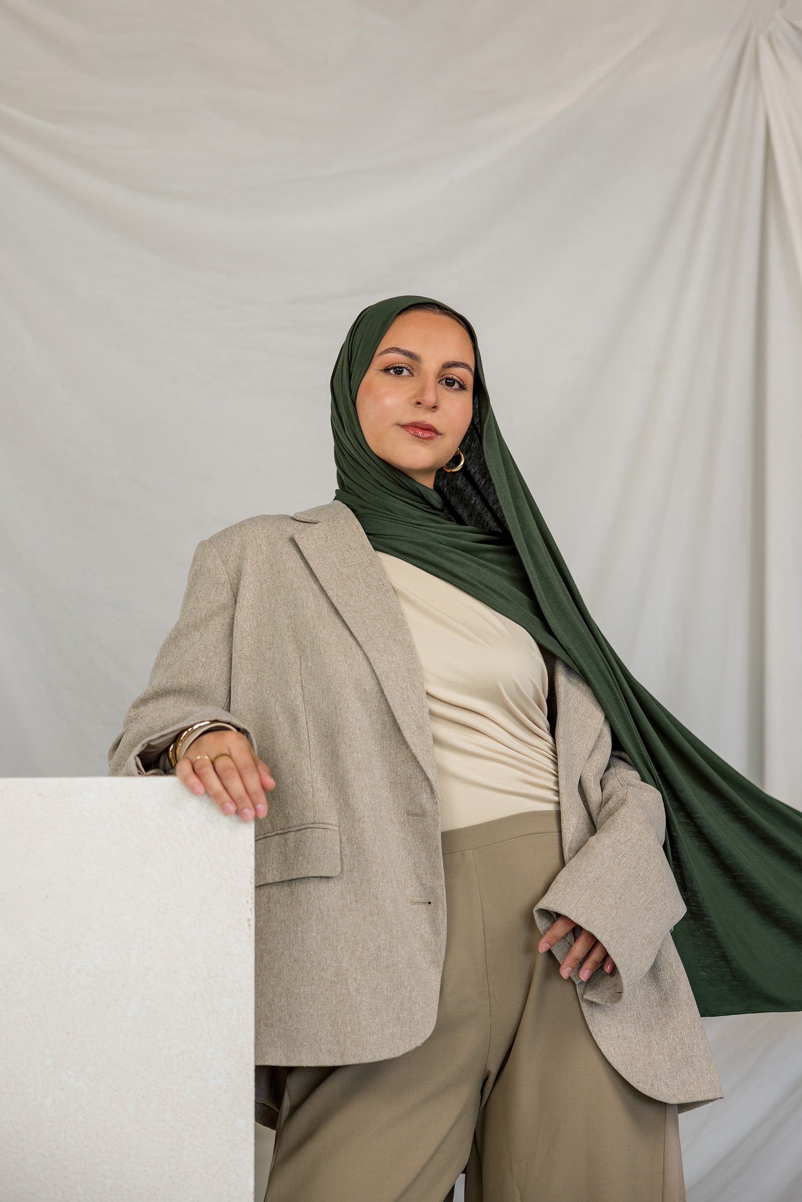 Model wearing Hunter Green Jersey Lite styled in a loose wrap, showcasing its stretchy, wrinkle-resistant drape.