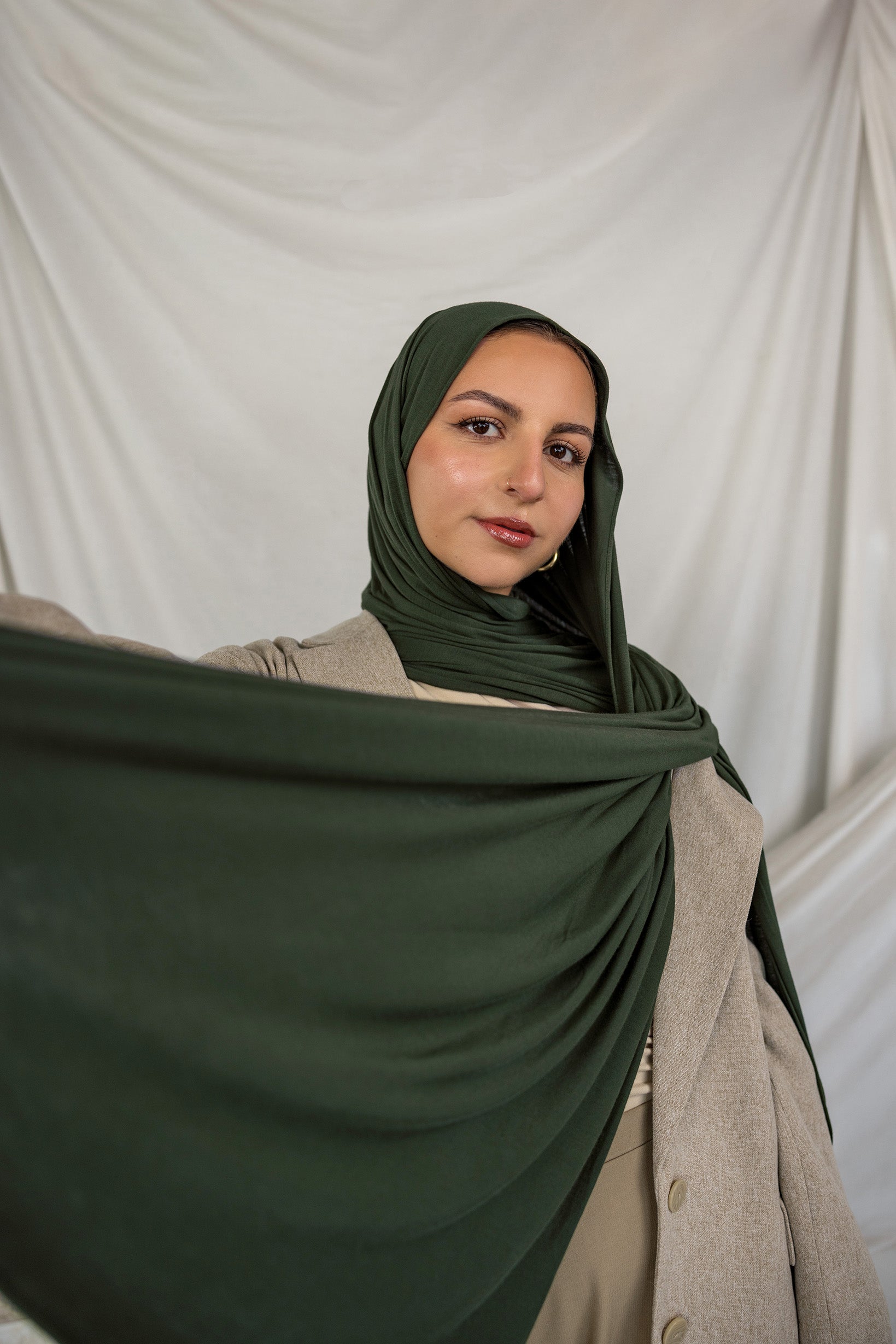 Model wearing Hunter Green Jersey Lite styled in a loose wrap, showcasing its breathable, wrinkle-resistant drape.