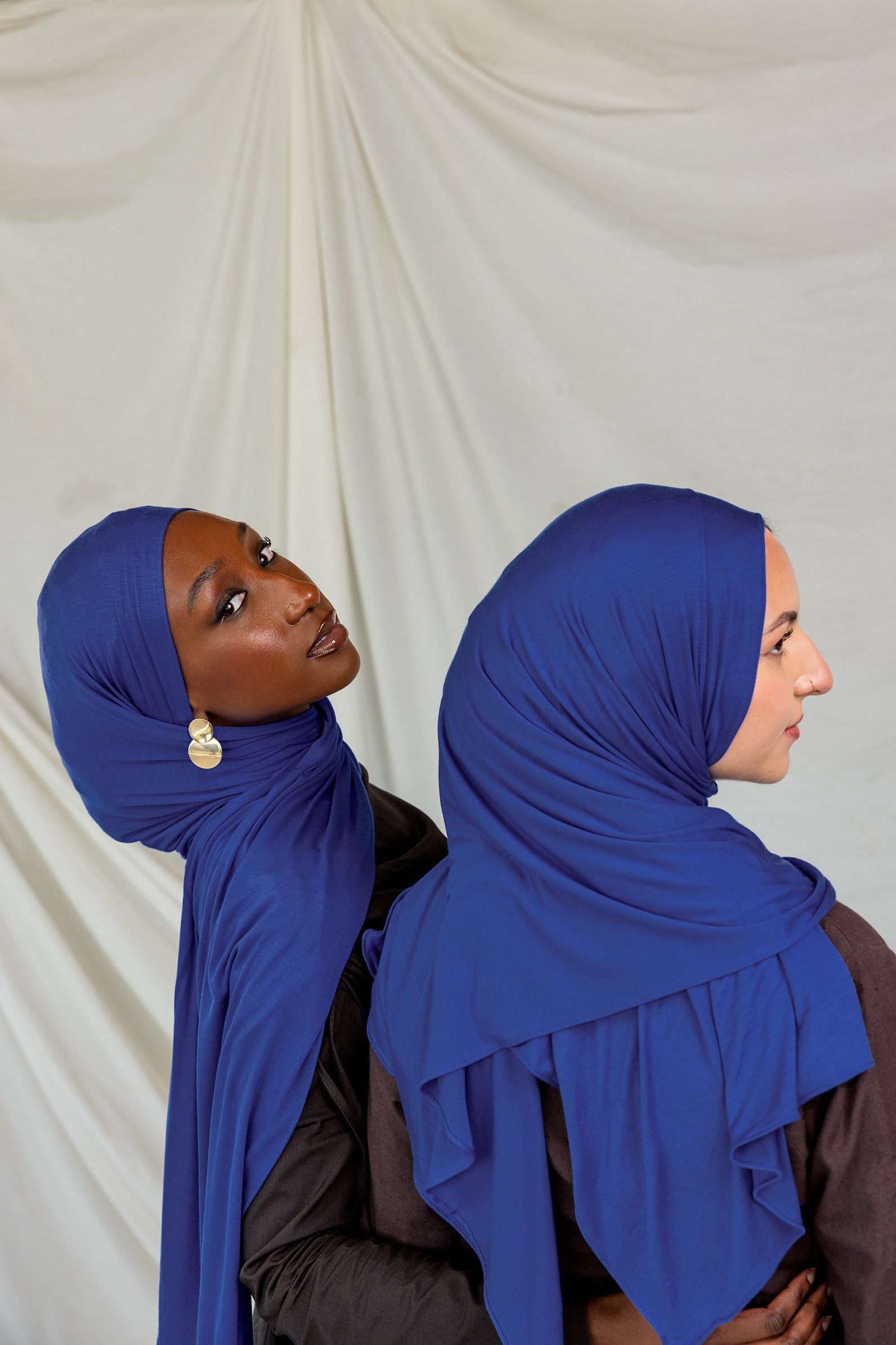 Two models wearing Ocean Blue Jersey Lite, one looking out and one front facing displaying its deep, saturated blue in different angles.