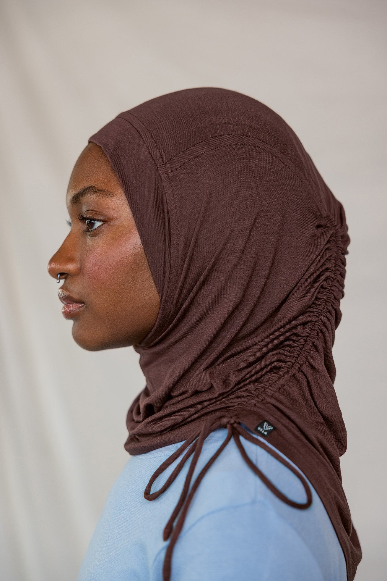 Model wearing Espresso Ruching Lite highlighting the ruched detail from the side profile.