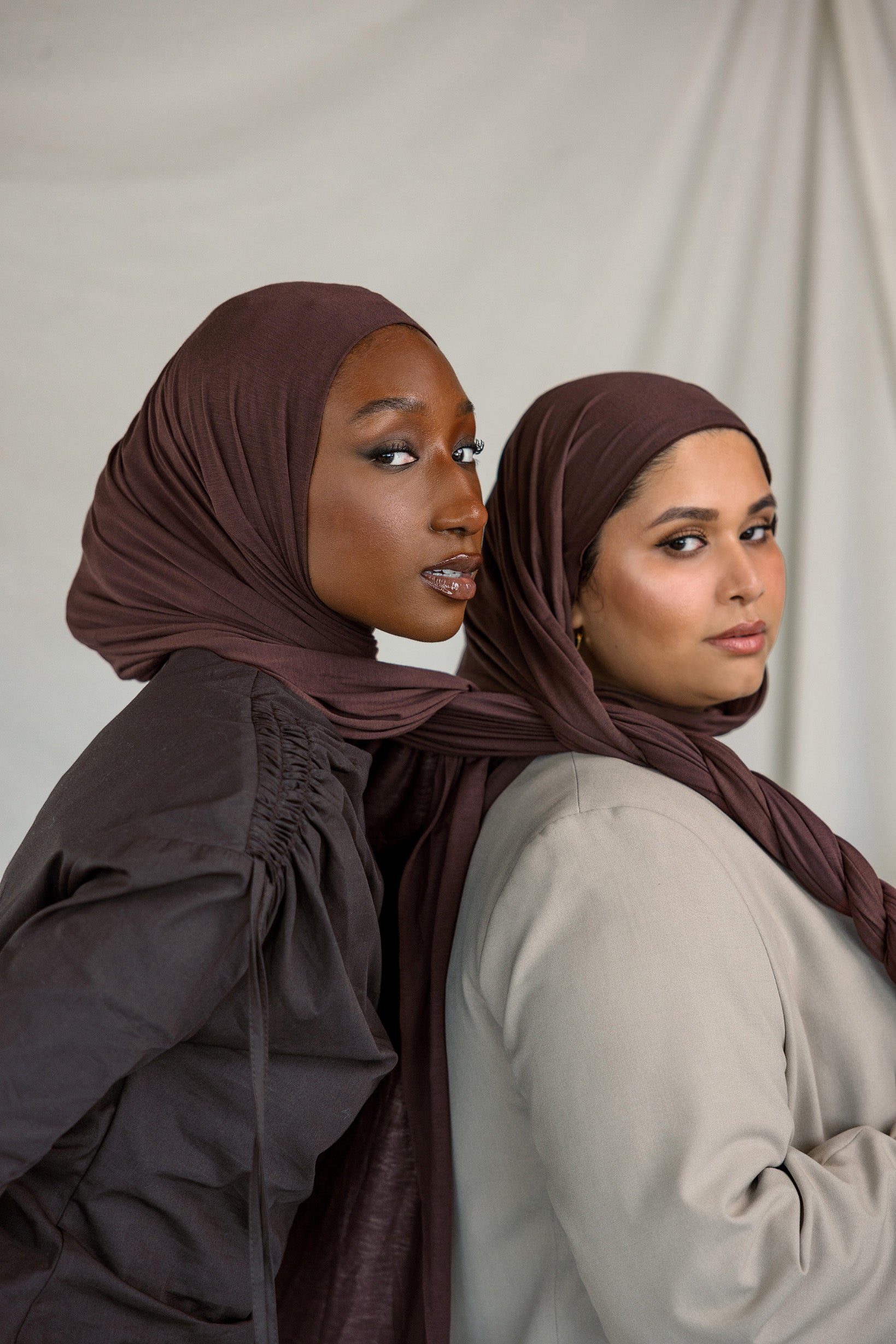 Two models wearing Espresso Jersey Lite, demonstrating its malleable nature and rich chocolate color.