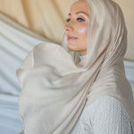 Model wearing woven hijab in a soft neutral tone with warm undertones and lightweight texture