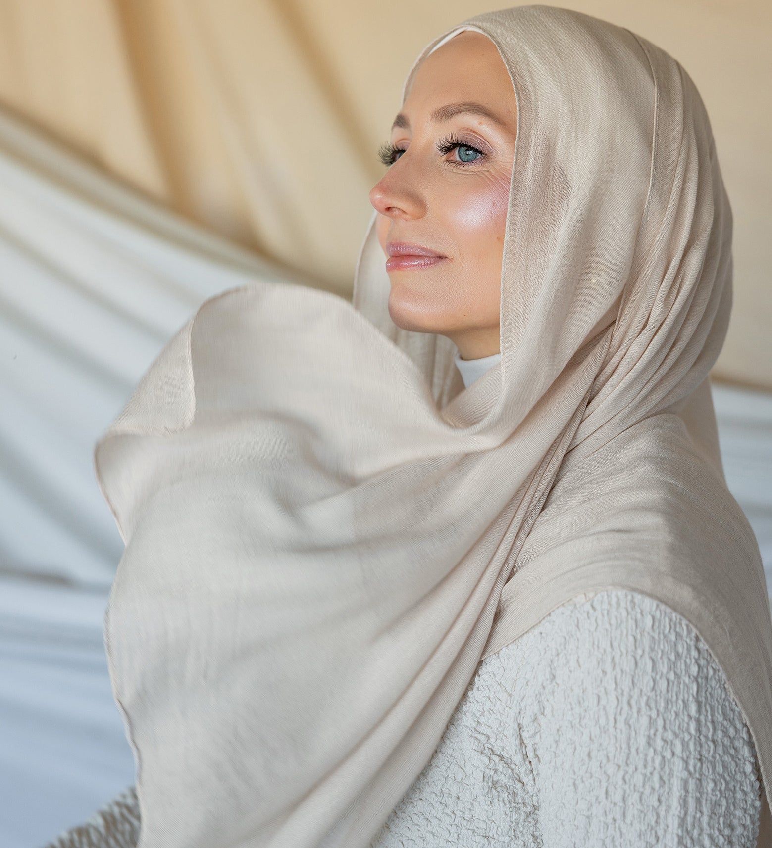 Model wearing woven hijab in a soft neutral tone with warm undertones and lightweight texture