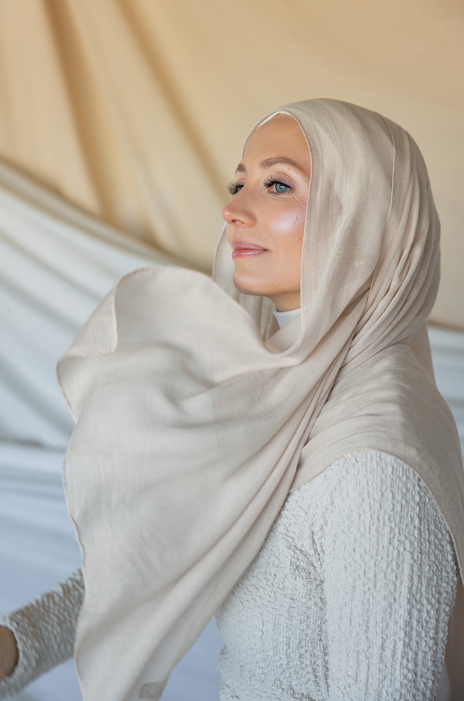 Model wearing woven hijab in a soft neutral tone with warm undertones and lightweight texture