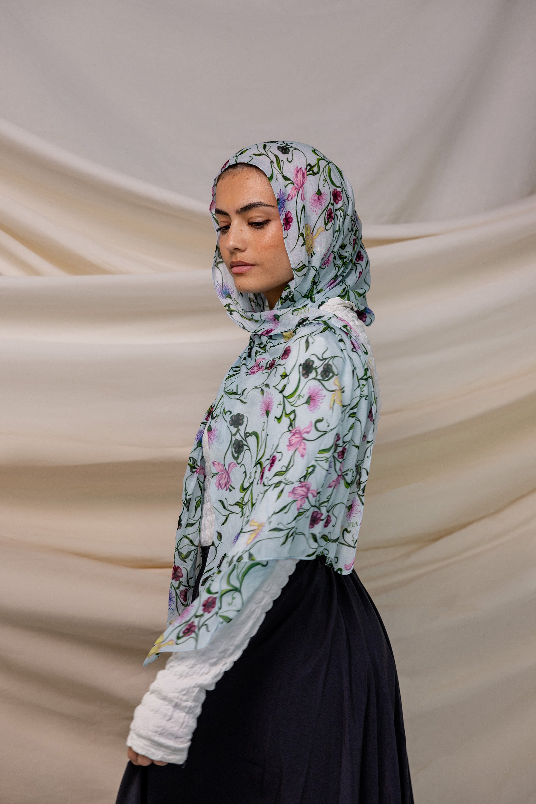 VELA baby blue hijab with small floral print, soft and light for everyday wear.