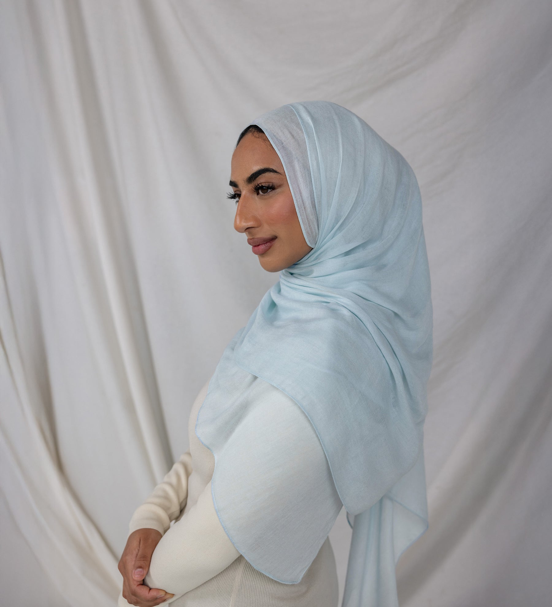 This is a lightweight woven hijab draped beautifully on a model showing the color  Fuji Blue is a serene, sky-inspired blue, named after the majestic Mount Fuji